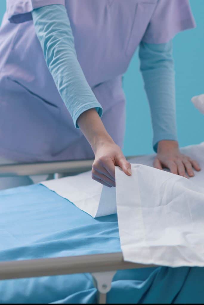 Nurse making hospital bed